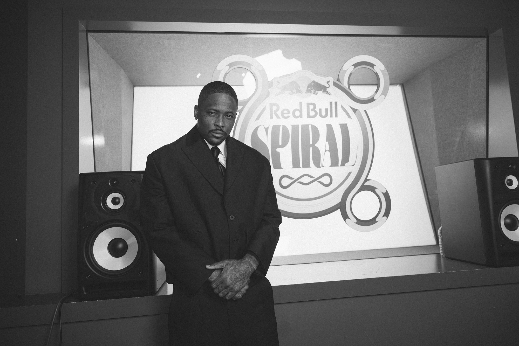 YG photographed in black and white in front of the Red Bull Spiral logo